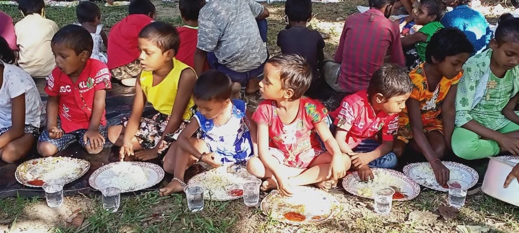 Children sitting in a row eating nutritious food
