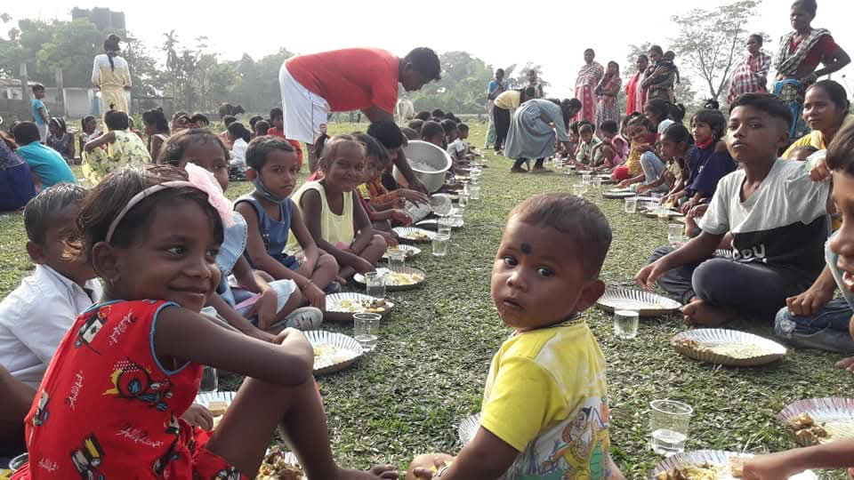 Children receiving nutritious meals and looking at the camera